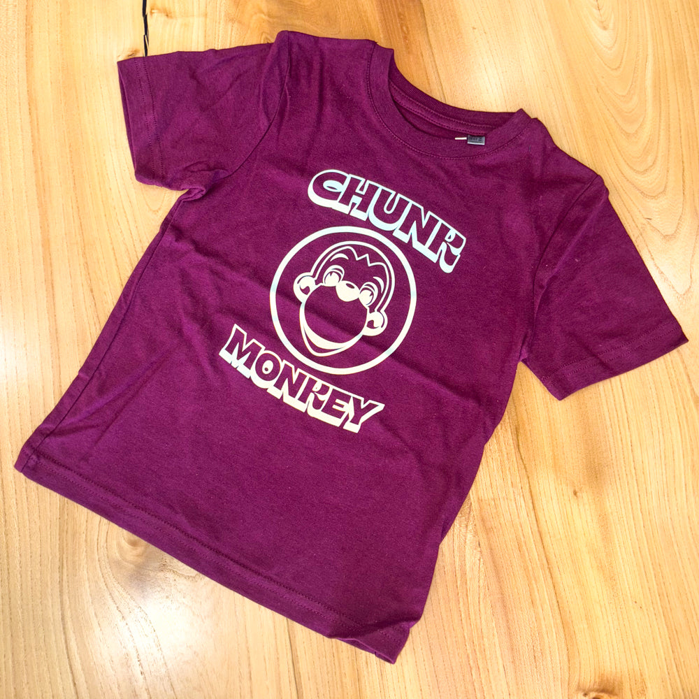 Burgundy t-shirt with 'Chunk Monkey' design on a wooden surface