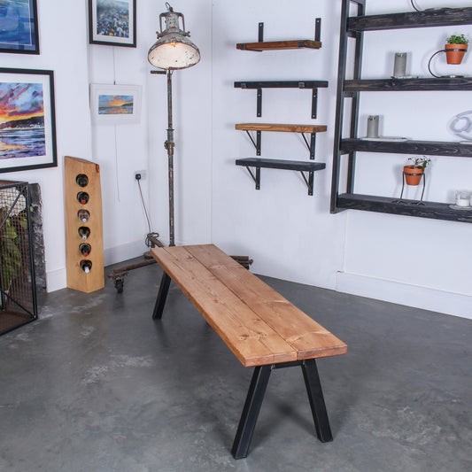 Extra Chunky Chunk Two bench in a rustic industrial setting. Features inverted V shaped legs and a farmhouse stain.