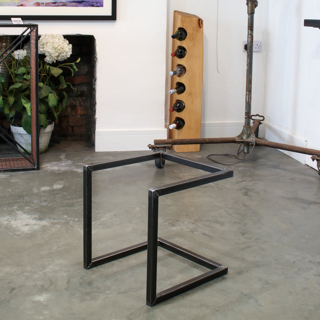 The frame of the cantilever stool in a rustic industrial setting