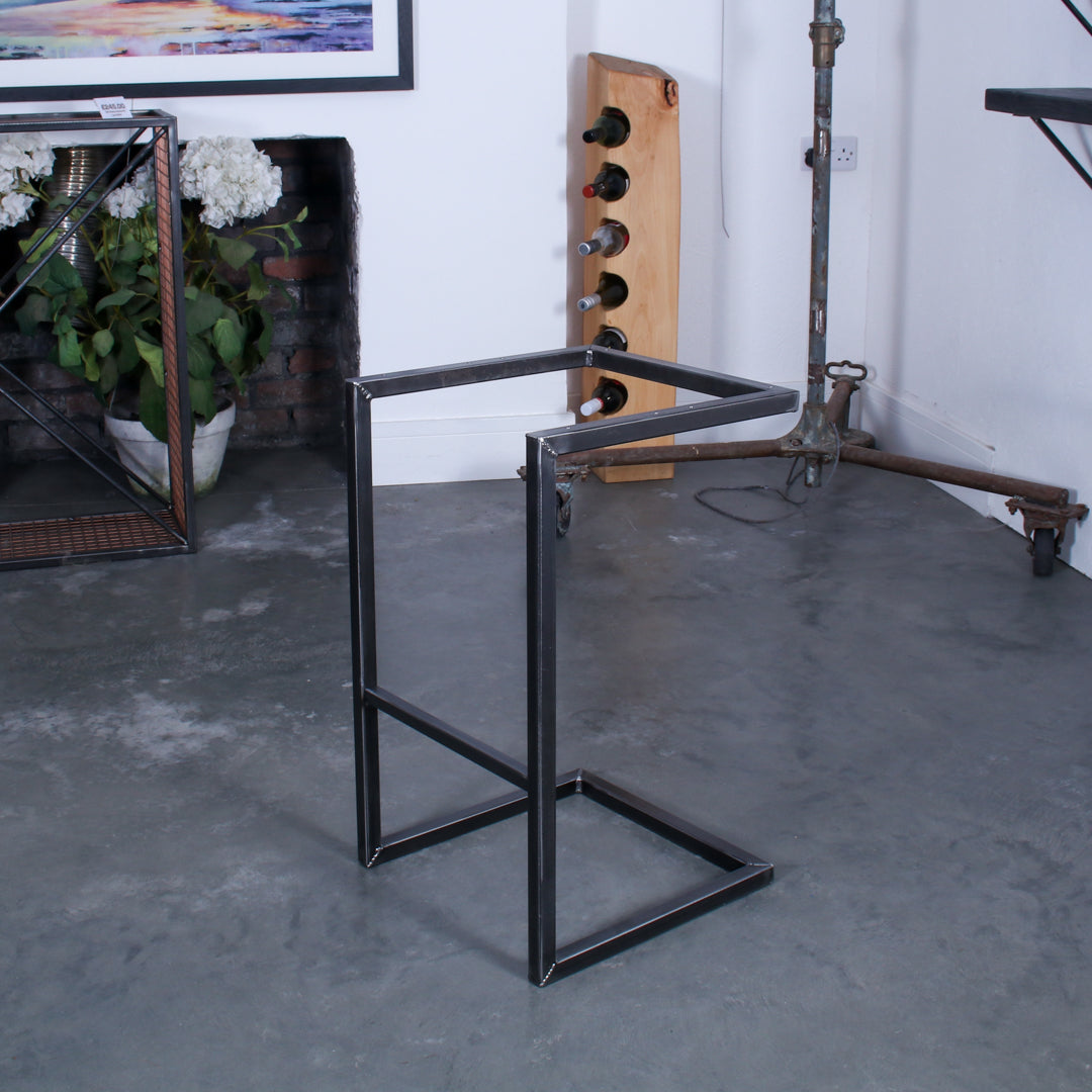 The frame for a high cantilever rustic industrial stool with a footrest.