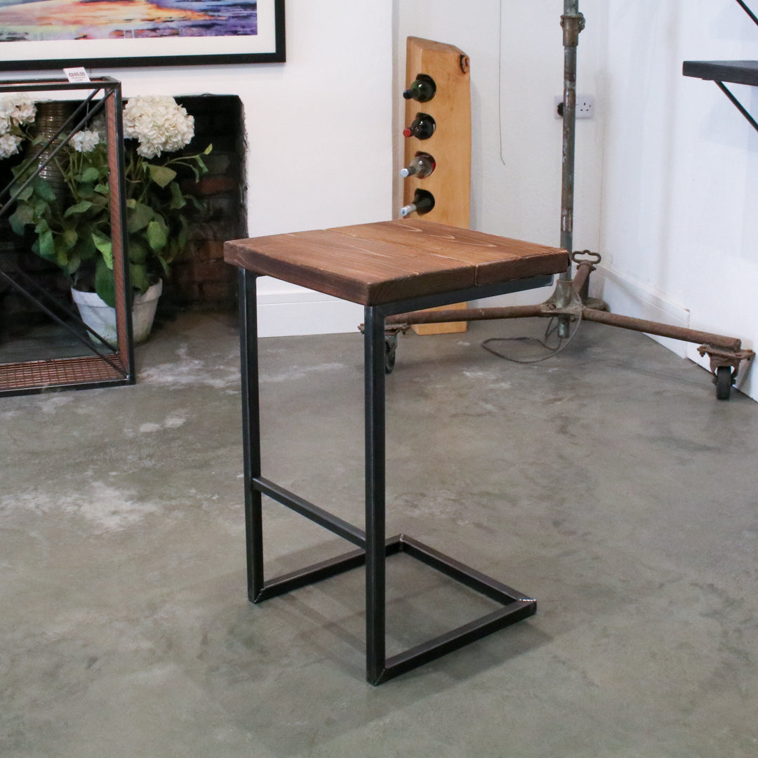 Rustic industrial stool with footrest and Extra Chunky walnut seat on a high cantilever frame.