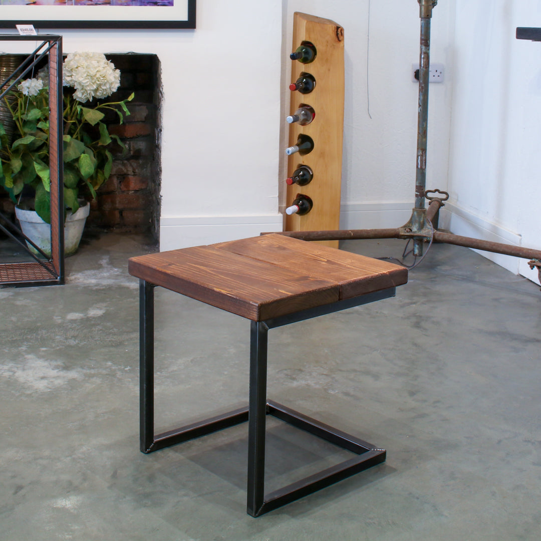 Rustic industrial stool with footrest and Extra Chunky walnut seat on a low cantilever frame.