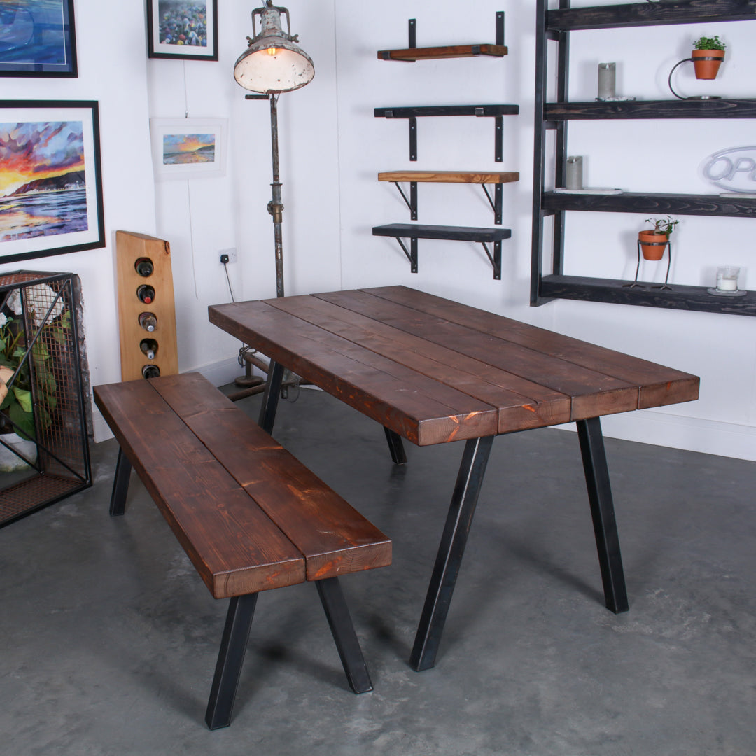 Walnut stained Extremely Chunky 4 board solid wood dining table with a bench, both featuring 'Chunk Two' legs in rustic industrial room