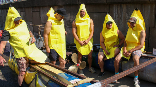 Men dressed in banana costumes getting ready to go to see in their handmade rustic raft for Mumbles Raft Race