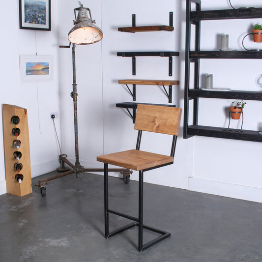 Handmade rustic cantilever bar stool with backrest, shown in an industrial-style interior setting.