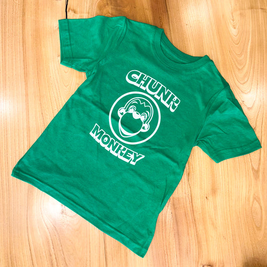 Green t-shirt with 'Chunk Monkey' design on a wooden surface