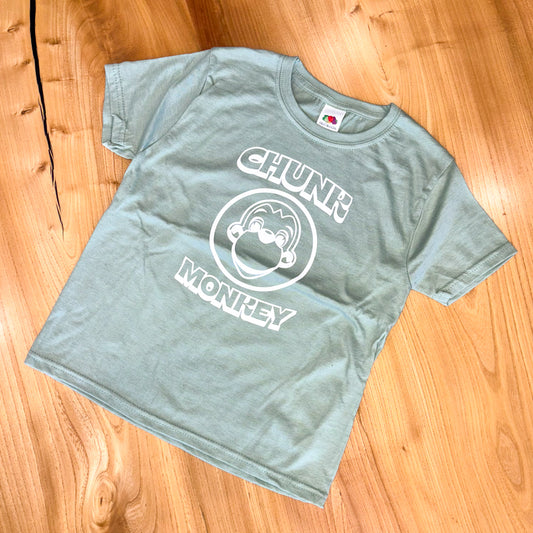 Light mint green t-shirt with 'Chunk Monkey' design on a wooden surface