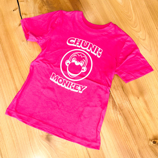 Pink t-shirt with 'Chunk Monkey' design on a wooden surface