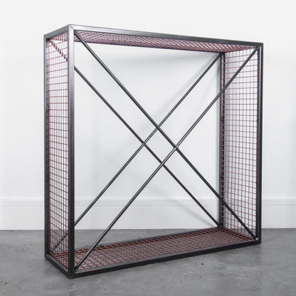 Side angle of an empty metal firewood holder against a white background