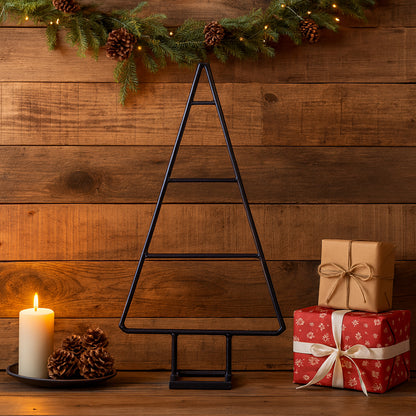 Decorative Christmas scene with a black metal tree, candles, and gift boxes on a wooden background.